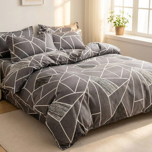 Housse de couette motif géométrique gris posée sur un lit dans une chambre lumineuse
