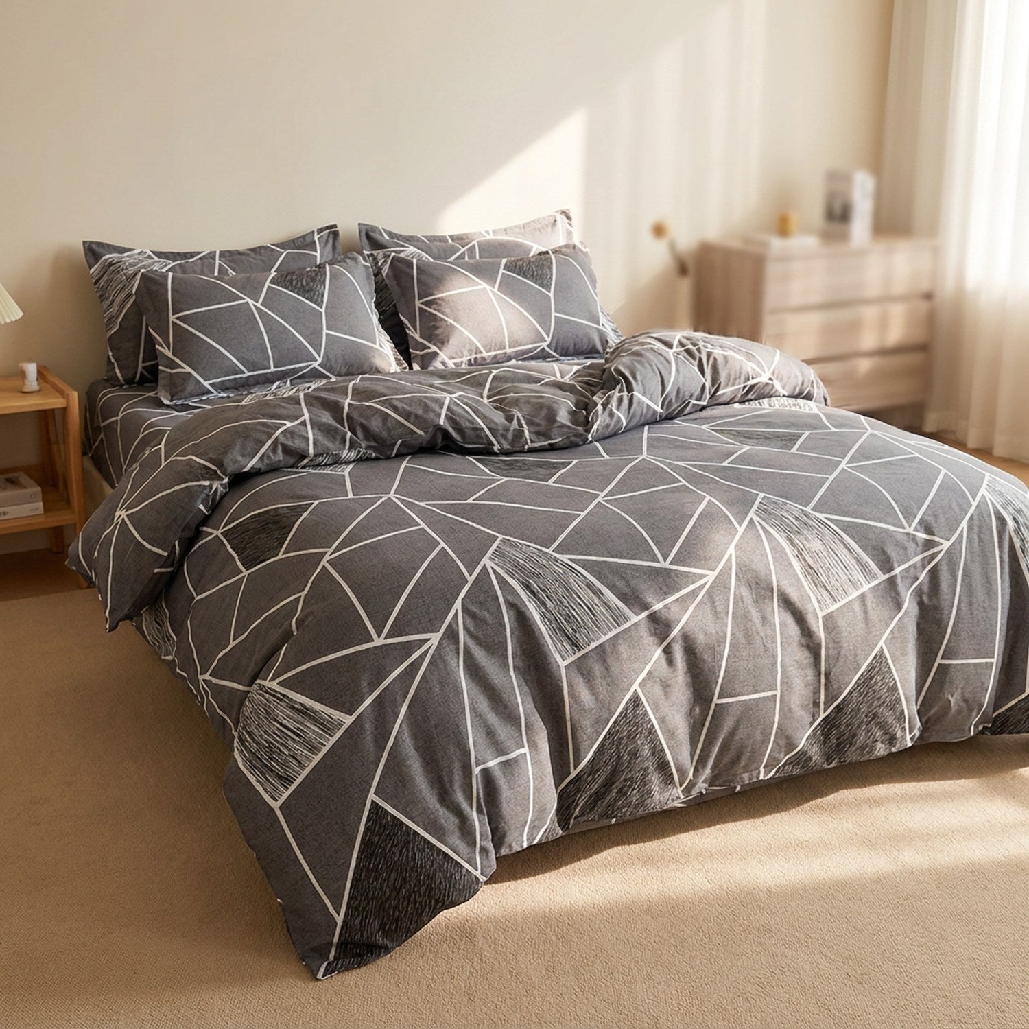 Housse de couette grise à motif géométrique blanc sur un lit dans une chambre lumineuse