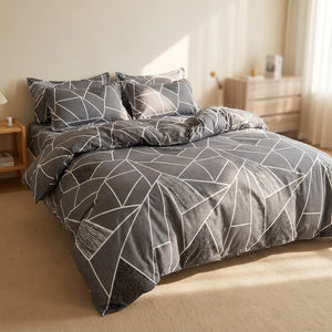 Housse de couette grise à motif géométrique blanc sur un lit dans une chambre lumineuse