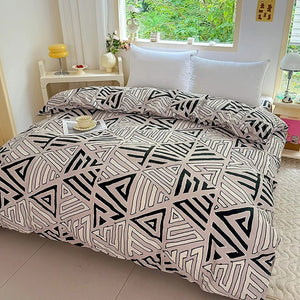 Housse de couette beige à motif triangle géométrique noir et blanc sur un lit avec oreillers blancs près d une fenêtre