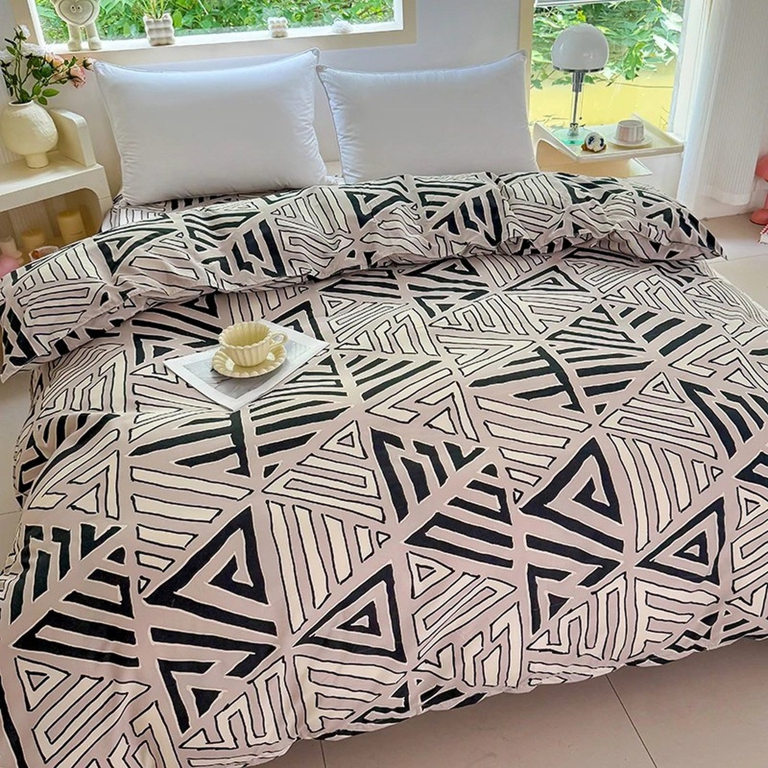 Vue rapprochée de la housse de couette beige à imprimé triangle géométrique noir sur un lit fait
