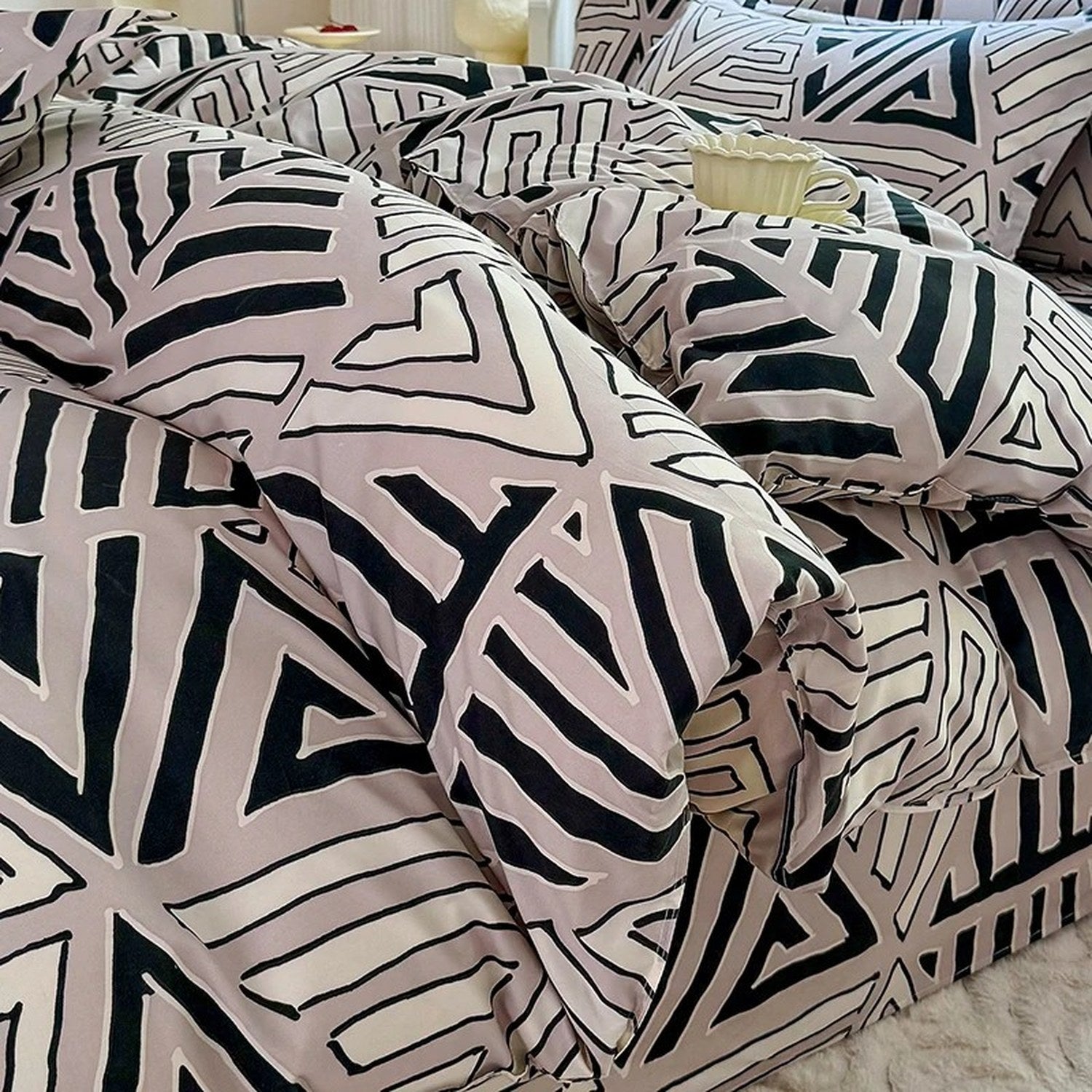 Détail du plissé de la housse de couette montrant le motif triangle géométrique noir et blanc