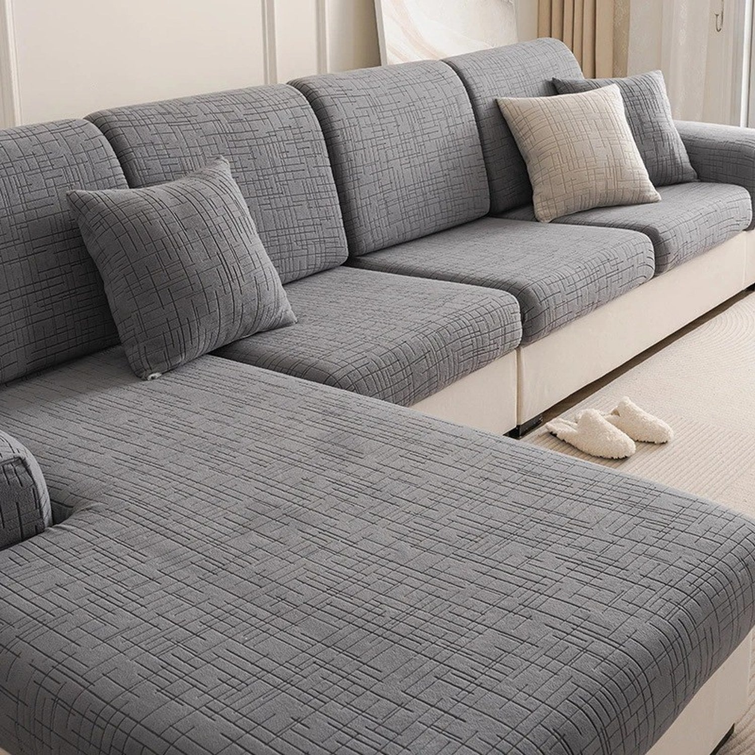 Canapé d'angle gris avec coussins habillés de housses en jacquard texturé