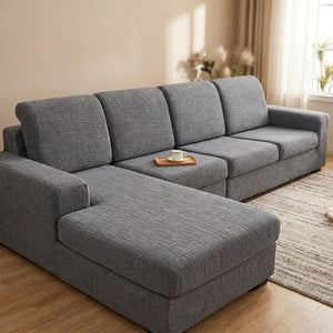 Housse de coussin de canapé grise en jacquard installée sur un canapé d'angle dans un salon lumineux