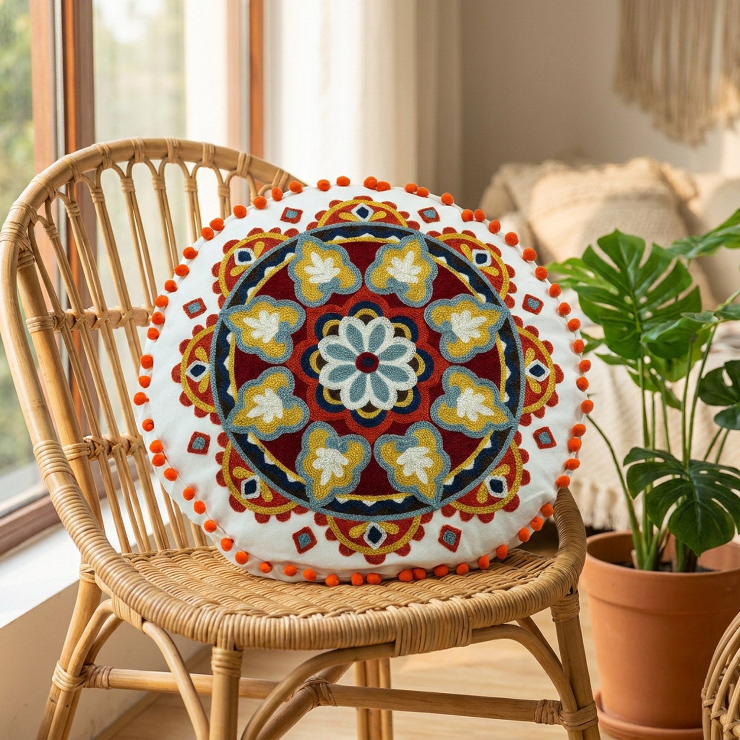 Housse de coussin ronde bohème sur un fauteuil en rotin près d'une fenêtre avec une plante