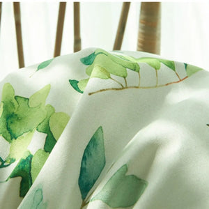 Gros plan sur le tissu à feuillage vert aquarelle de la housse de coussin