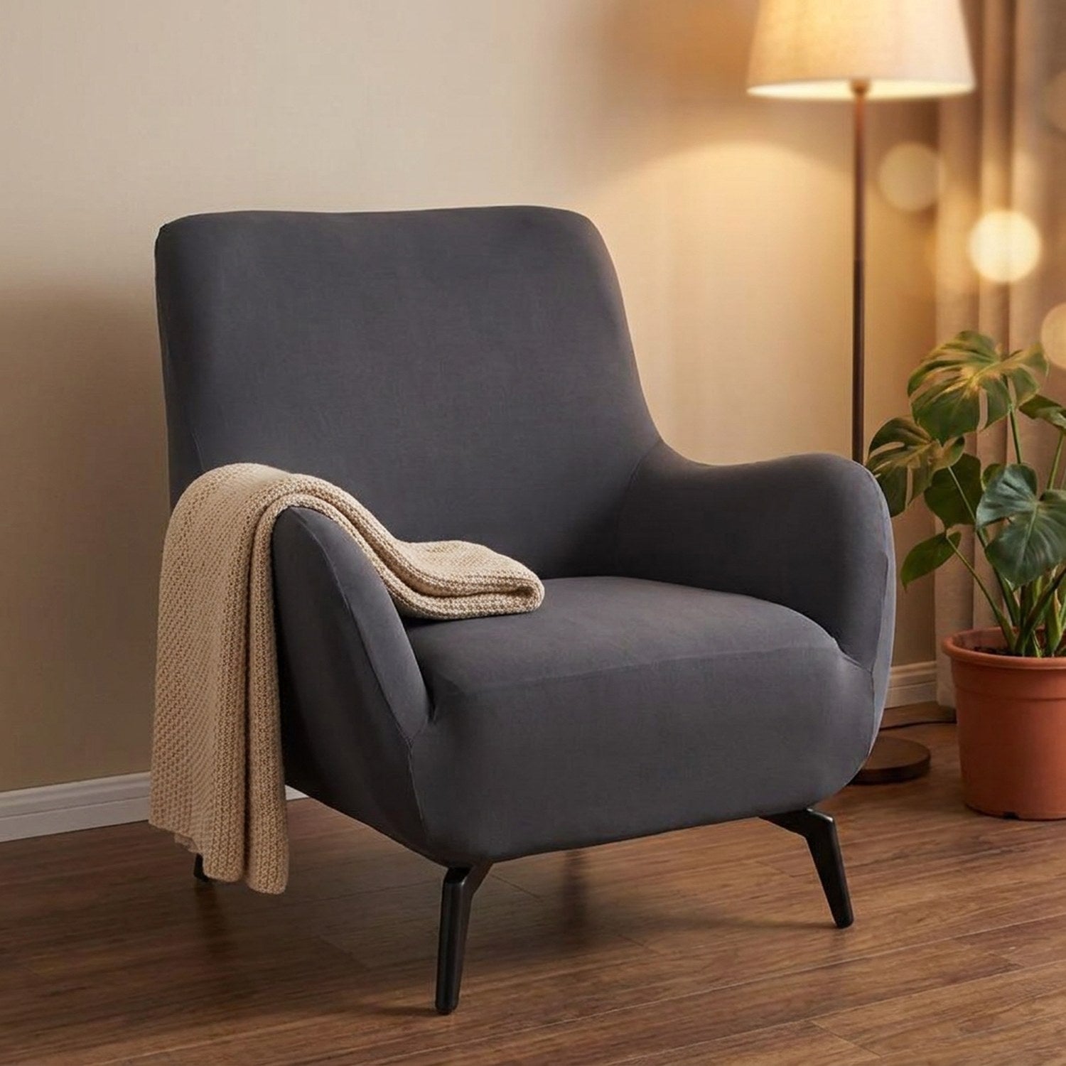 Housse de fauteuil extensible gris anthracite dans un coin lecture chaleureux
