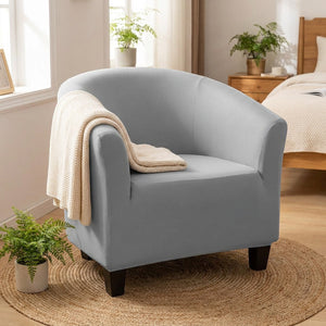 Fauteuil crapaud avec housse grise dans une chambre cosy avec un plaid