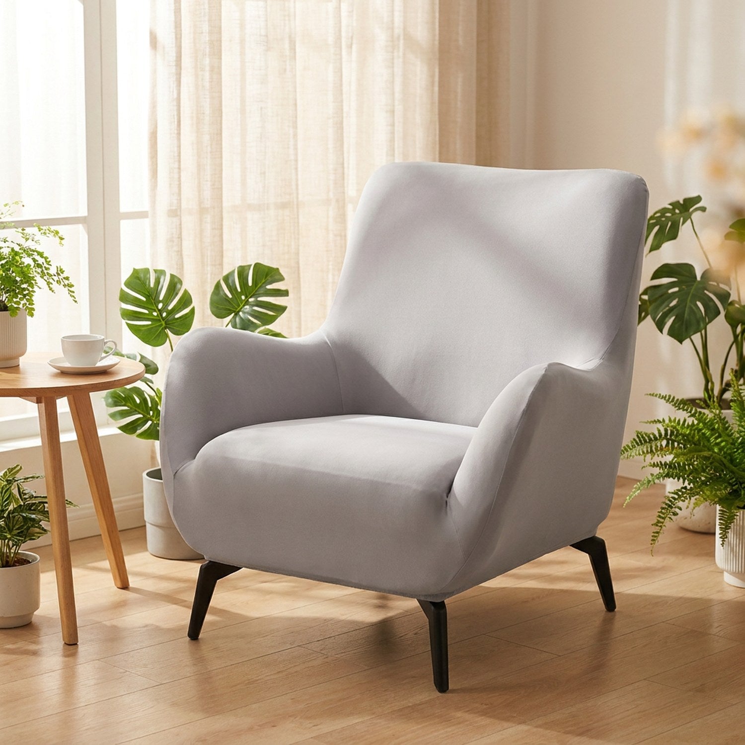 Housse de fauteuil extensible gris clair près d'une fenêtre ensoleillée