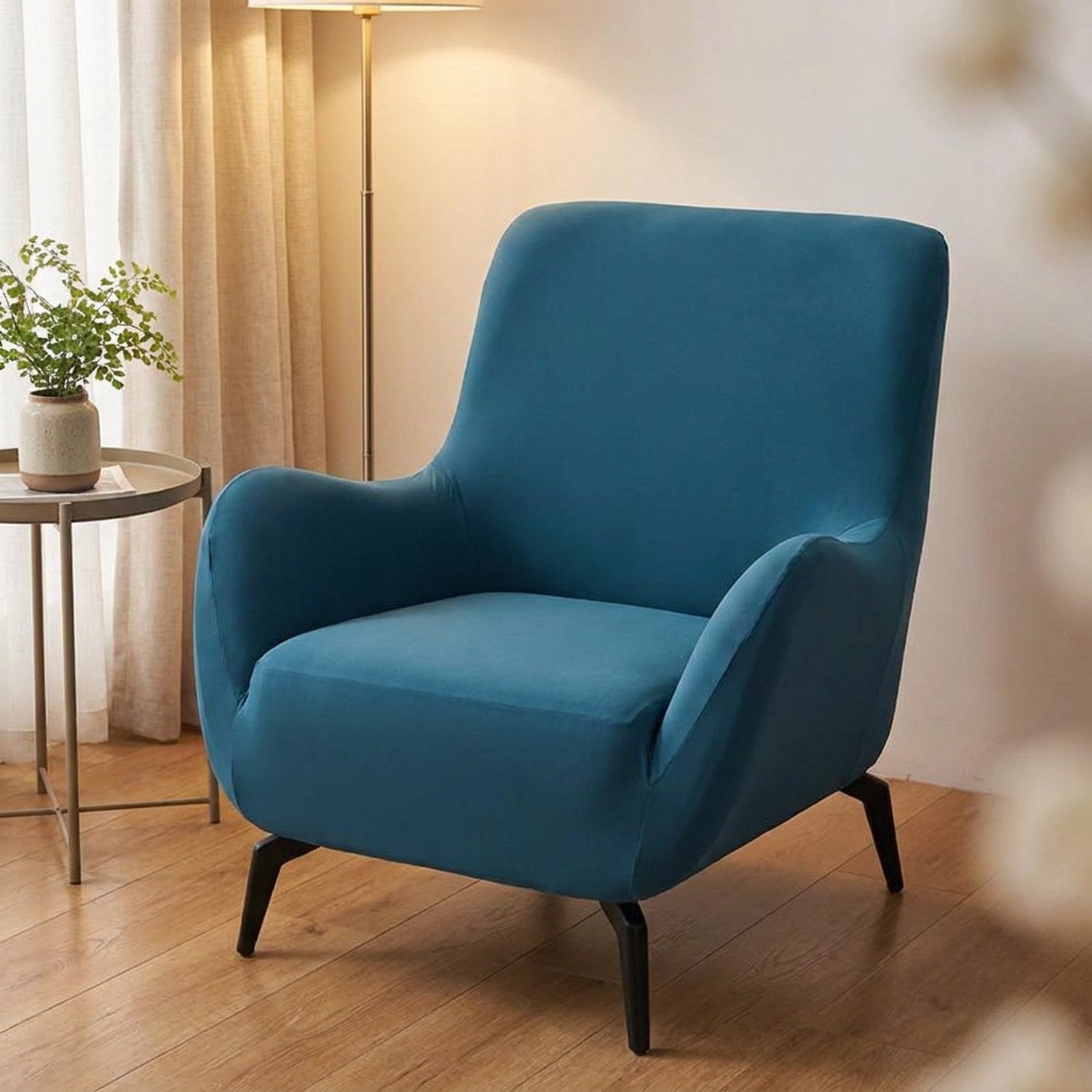 Housse de fauteuil extensible bleu canard sur un fauteuil club dans un salon lumineux