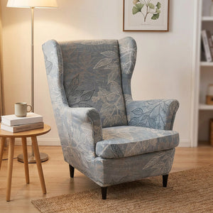 Fauteuil à oreilles habillé d'une housse à motif feuillage dans un coin lecture