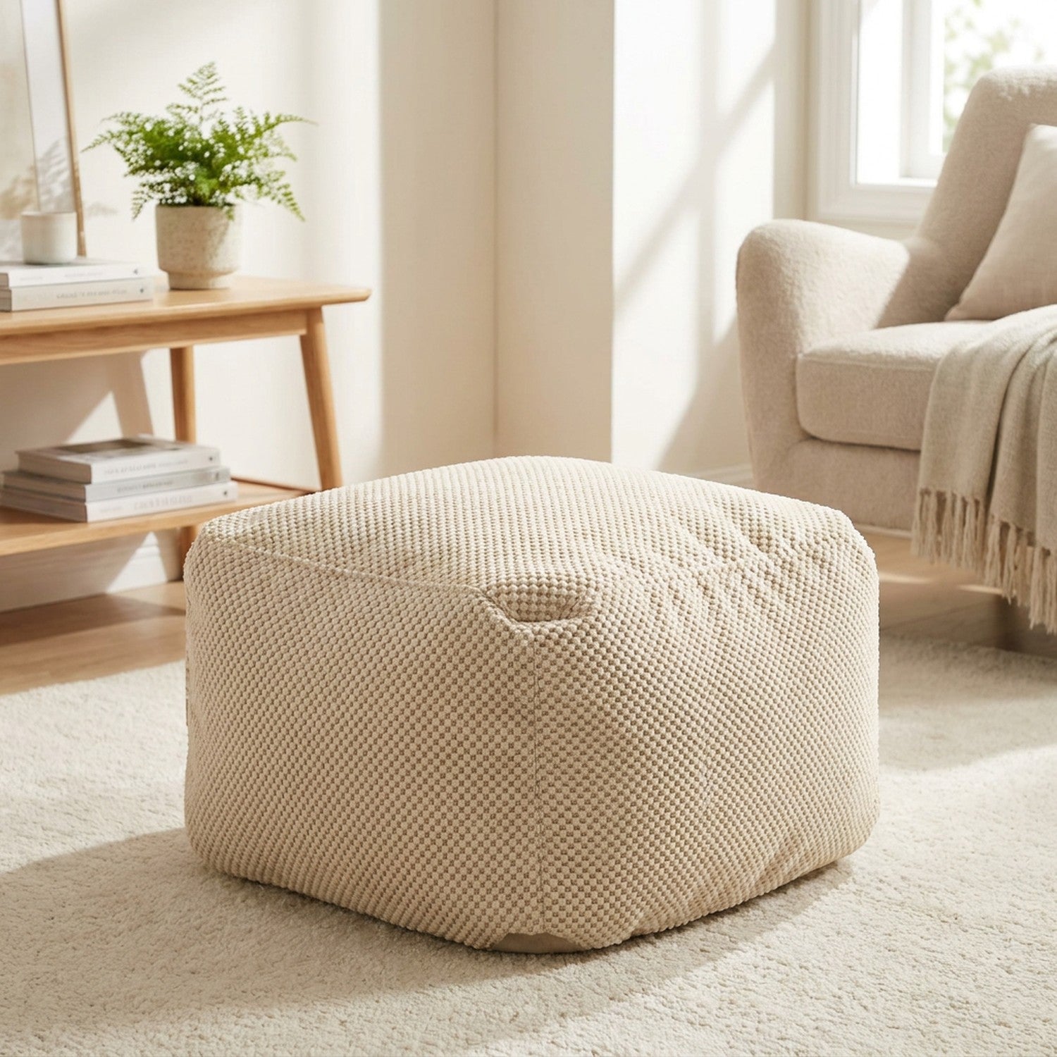 Pouf poire carré en coton gaufré beige posé sur un tapis clair