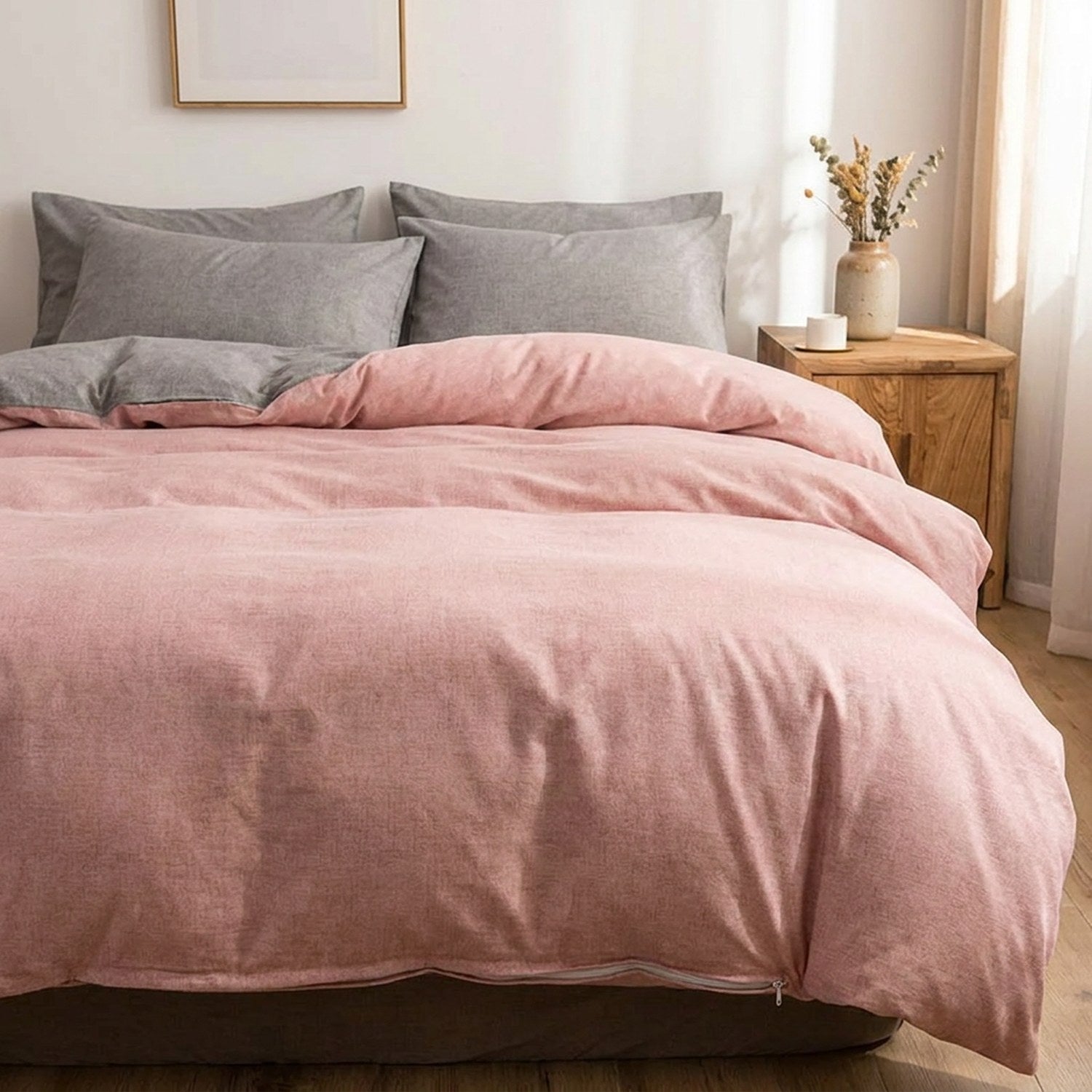 Housse de couette rose poudré bicolore installée sur un lit fait