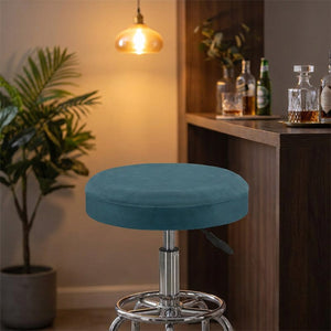 Housse de tabouret en velours bleu canard sur un tabouret dans un coin bar