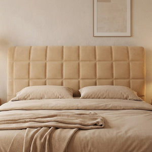 Housse de tête de lit capitonnée beige dans une chambre minimaliste aux tons neutres
