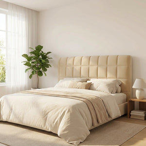 Housse de tête de lit beige matelassée dans une chambre lumineuse avec plante verte