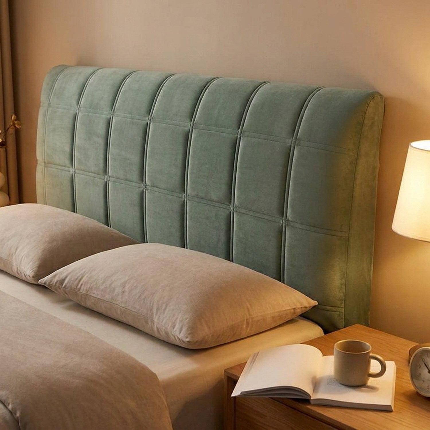 Housse de tête de lit vert sauge dans une chambre chaleureuse éclairée le soir