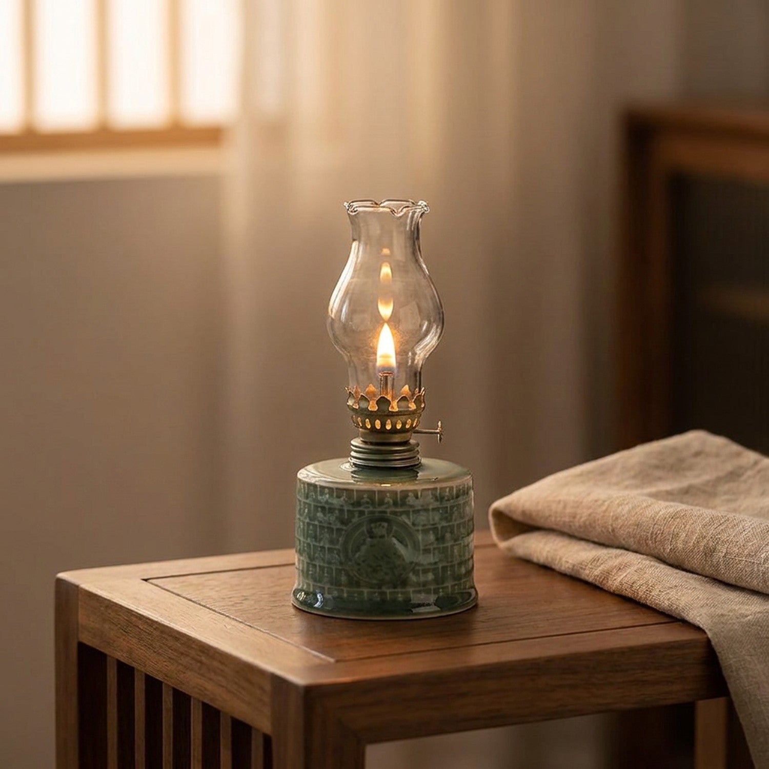 Lampe à pétrole céramique céladon turquoise allumée sur une table basse en bois