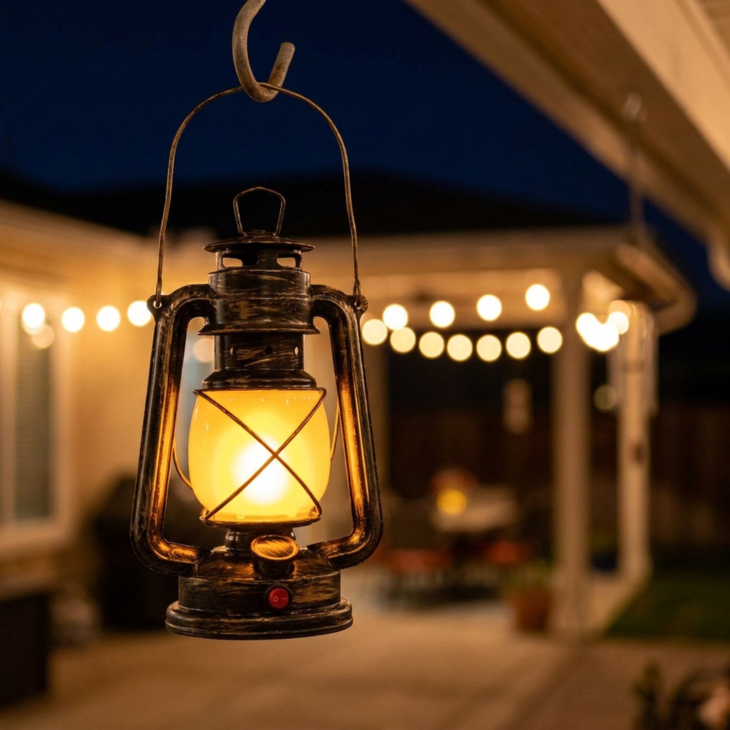 Lampe suspendue à un crochet sous une terrasse extérieure la nuit