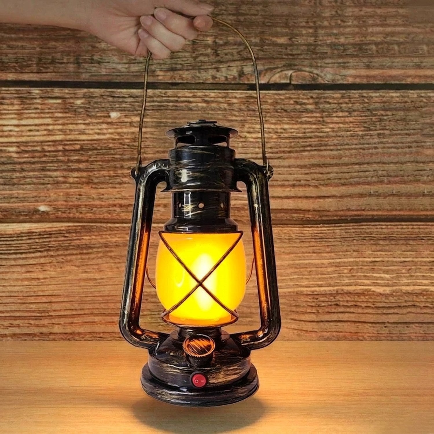Lampe rétro tenue à la main par sa poignée devant un mur en bois