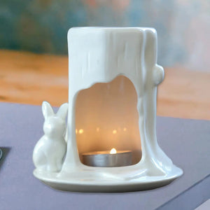 Brûleur à huile en céramique blanche design lapin tronc d'arbre avec bougie allumée