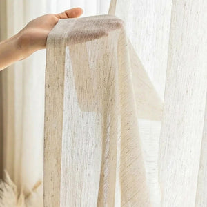 Détail du tissu tulle effet lin tenu à la main devant une fenêtre