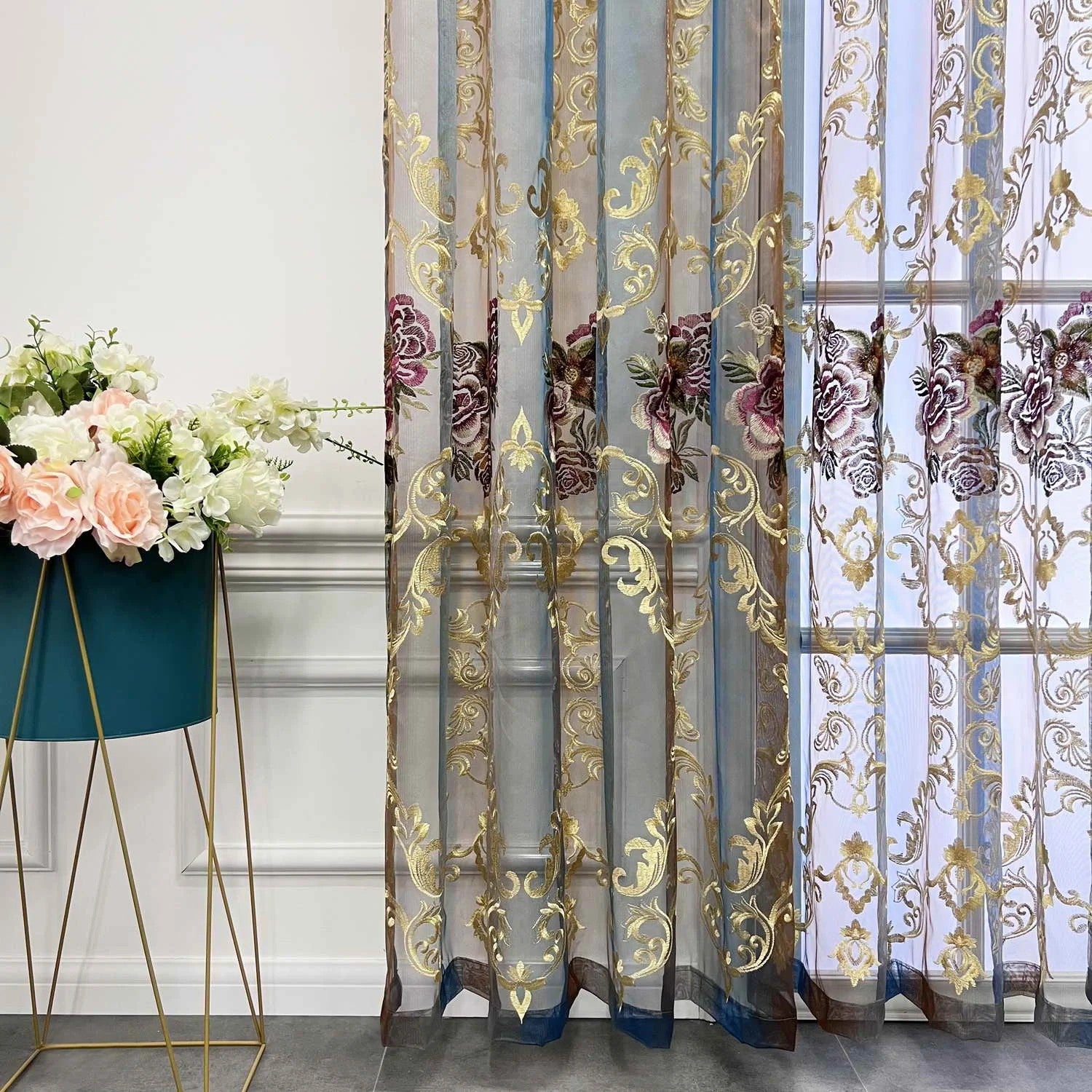 Vue rapprochée du rideau voilage avec motifs dorés et bouquets de roses brodées