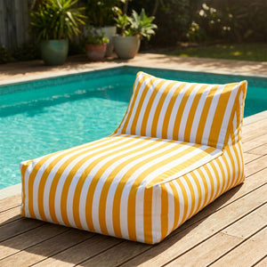 Pouf géant flottant à rayures jaune posé au bord d'une piscine