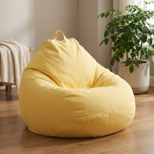 Housse de pouf poire jaune en tissu aspect lin dans un salon chaleureux