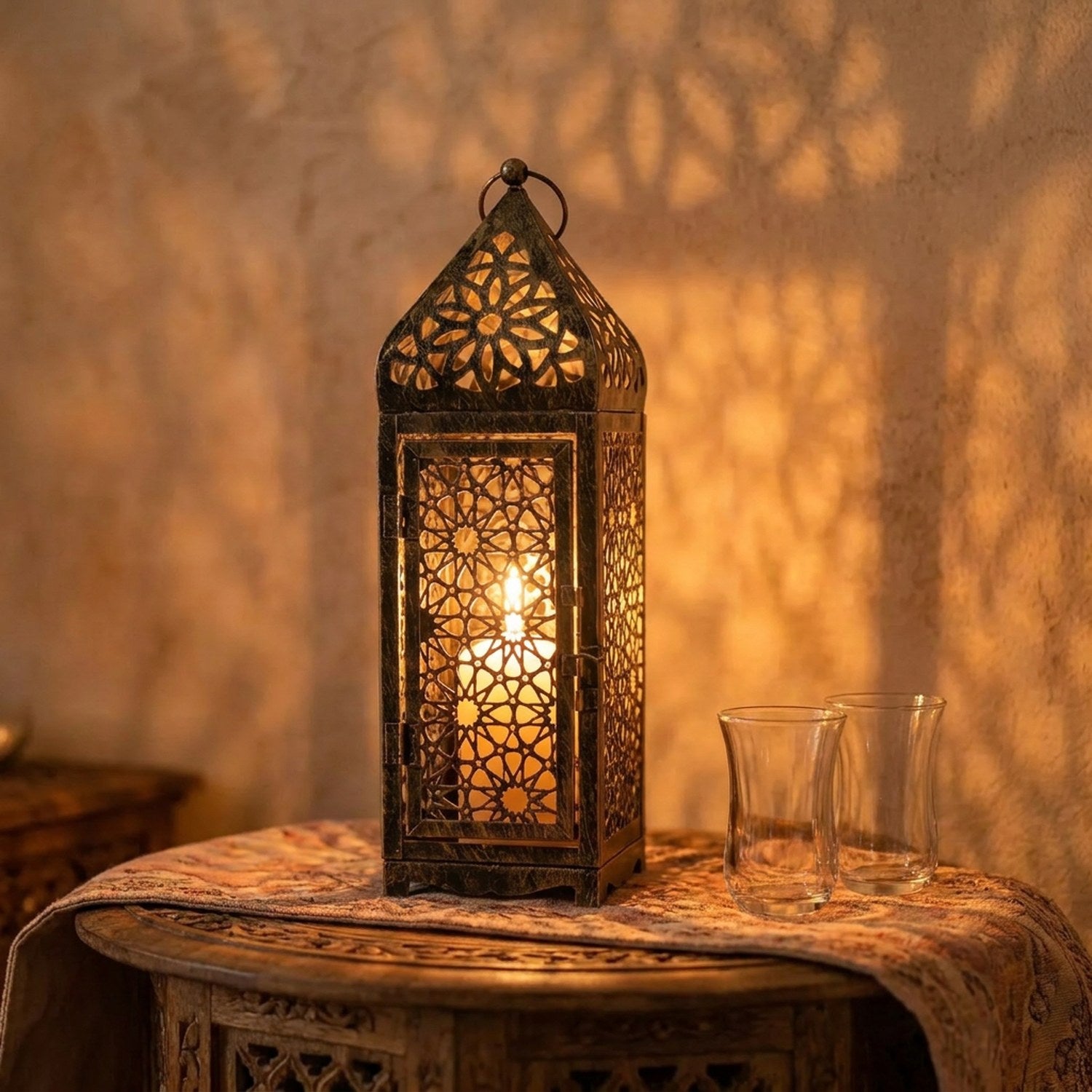 Lanterne marocaine posée sur une table orientale près de verres à thé