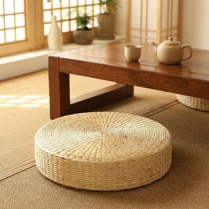 Pouf en paille près d'une table basse avec théière dans une pièce de style japonais