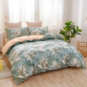 Parure de lit feuilles tropicales vertes sur un lit dans une chambre lumineuse avec plante verte