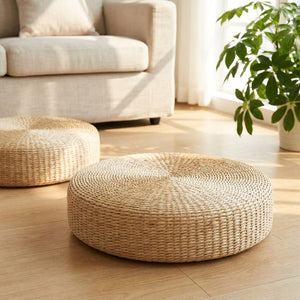 Deux poufs ronds en paille dans un salon lumineux avec canapé et plante