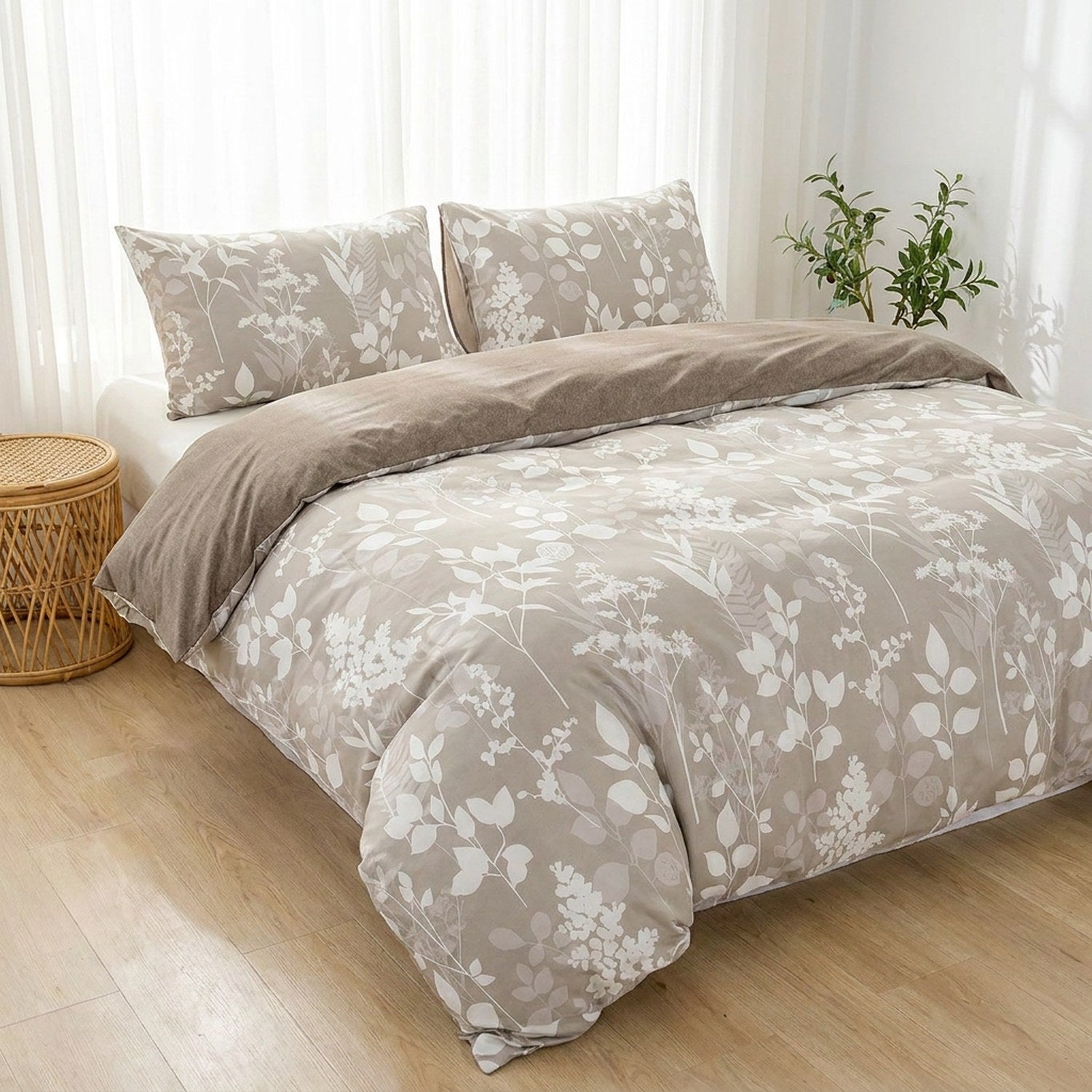 Parure de lit feuillage taupe sur un lit dans une chambre scandinave lumineuse avec plante verte