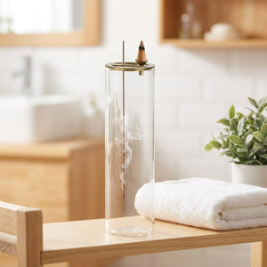 Porte-encens en verre dans une salle de bain spa avec serviette blanche