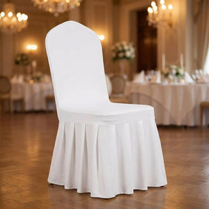 Détail de la jupe plissée d'une housse de chaise blanche dans une salle de réception