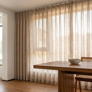 Rideau aspect lin beige le long d'une grande fenêtre dans un coin repas moderne