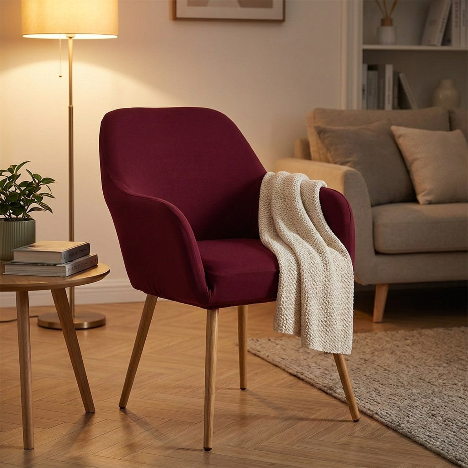 Housse de fauteuil bordeaux sur un fauteuil à accoudoirs dans un coin salon chaleureux