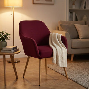Housse de fauteuil bordeaux sur un fauteuil à accoudoirs dans un coin salon chaleureux
