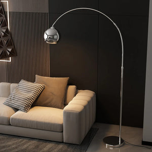 Lampadaire arc argenté dans salon sombre avec canapé beige