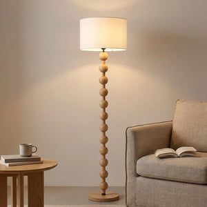 Lampadaire boulier bois naturel dans un coin lecture cosy avec fauteuil