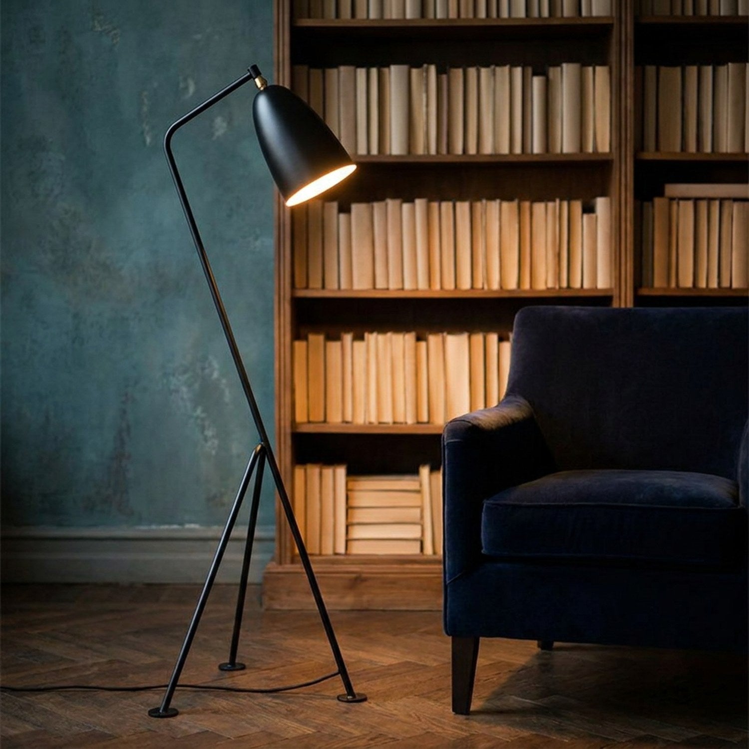 Lampadaire grasshopper dans un espace bibliothèque avec étagères et fauteuil