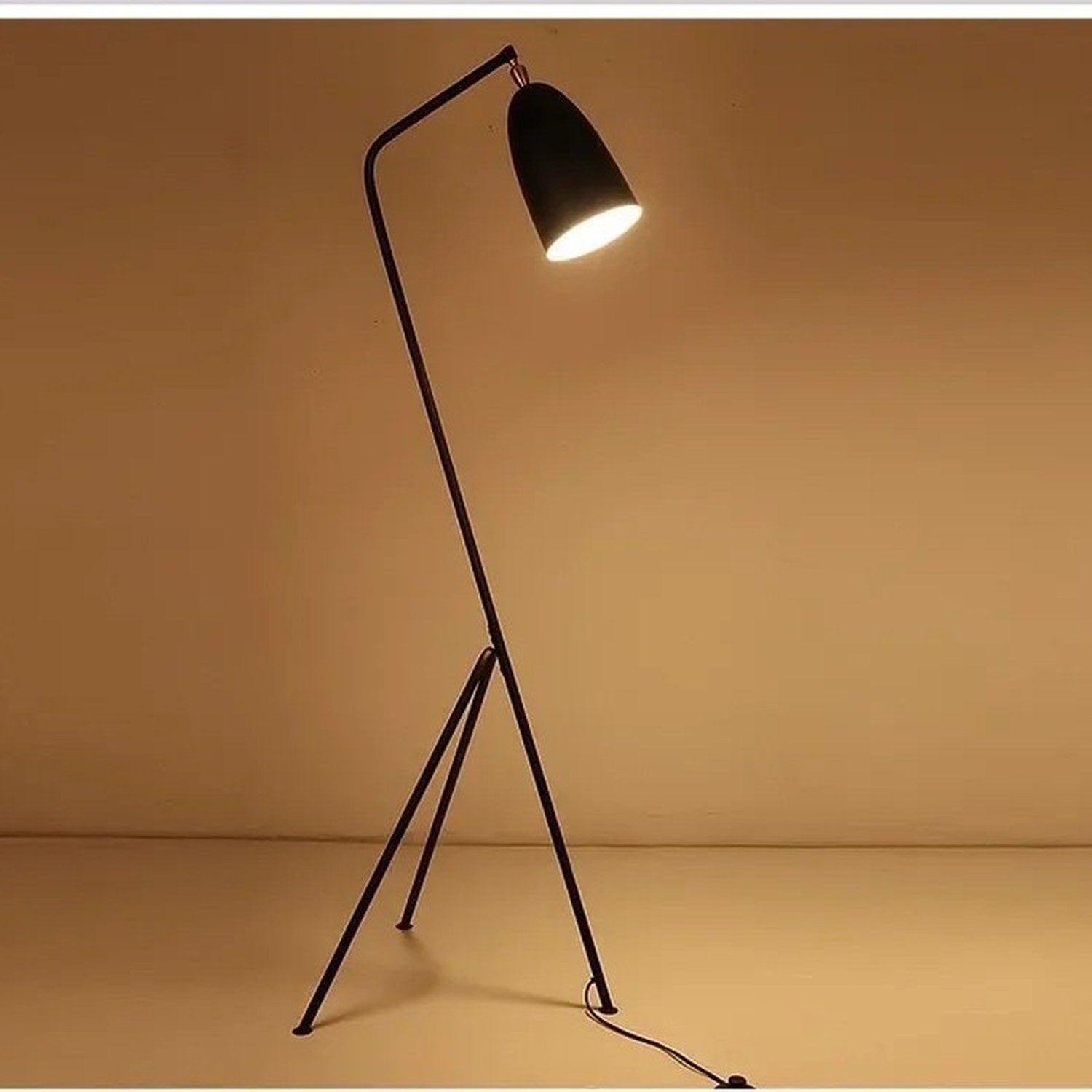 Lampadaire grasshopper allumé diffusant une lumière ambrée chaleureuse