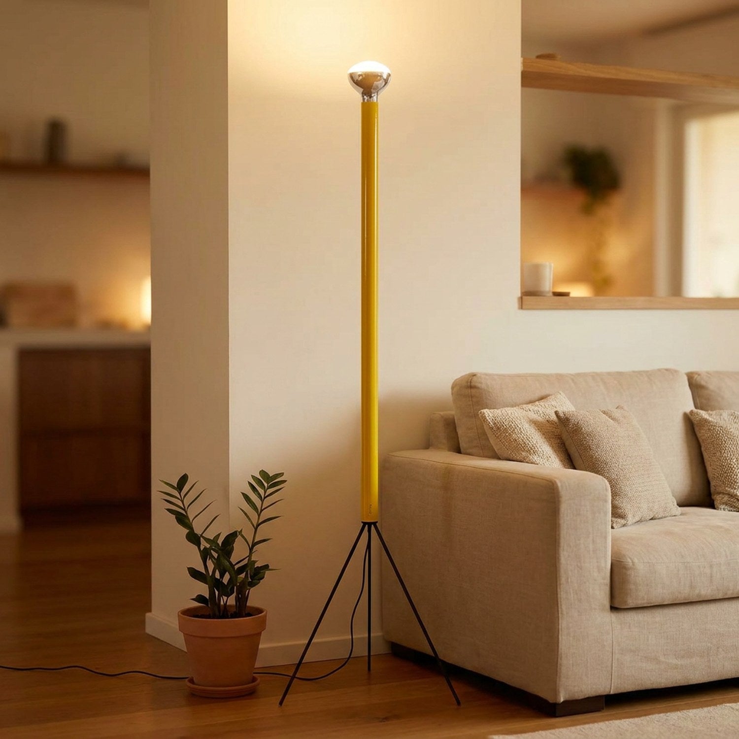 Lampadaire trépied jaune allumé dans un salon chaleureux