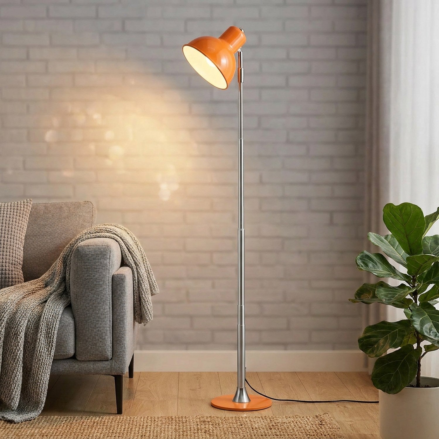 Lampadaire LED orange à pied chromé allumé dans un salon contemporain