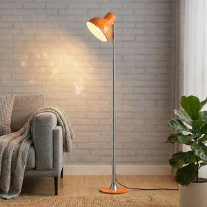 Lampadaire LED orange à pied chromé allumé dans un salon contemporain