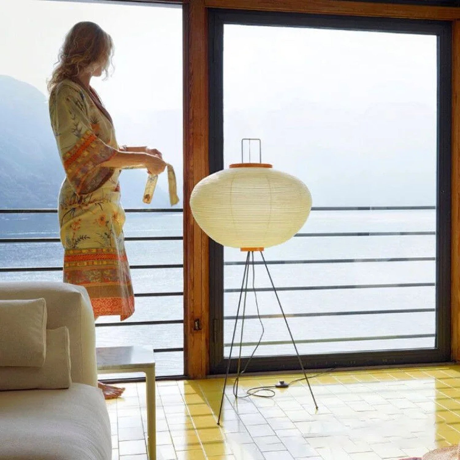 Femme en kimono devant lampadaire sphérique papier de riz salon avec vue extérieure