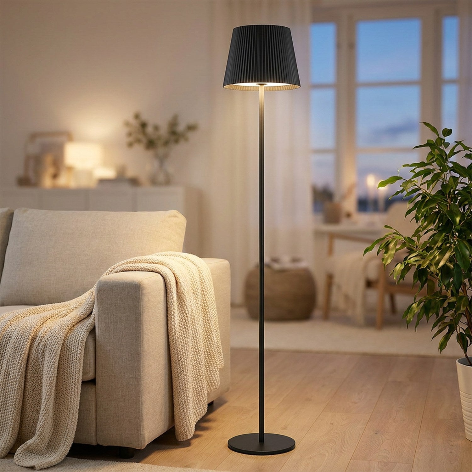 Lampadaire LED noir sans fil allumé près d'un canapé en lin dans un salon scandinave