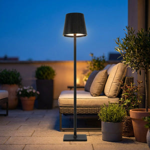 Lampadaire LED noir sans fil allumé sur une terrasse extérieure au crépuscule