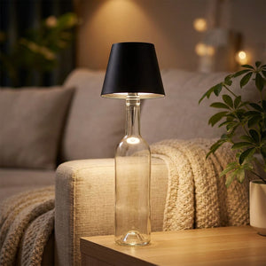 Lampe de table sans fil noire sur une bouteille près d'un canapé dans un salon cosy le soir